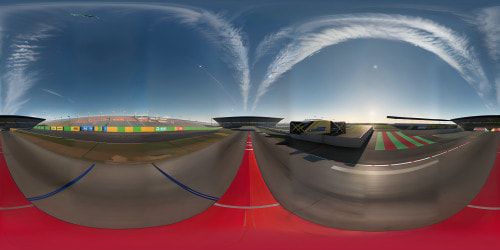 Ultra-realistic 3D Silverstone circuit, VR360 masterpiece. High res texture, slick tarmac, vibrant pit area. Sleek race cars in garage, gleaming under harsh neon lights. Patches of oil on floor, petrol cans in corner. Extreme quality sky, smoky, sunset hues, VR360 grandeur.